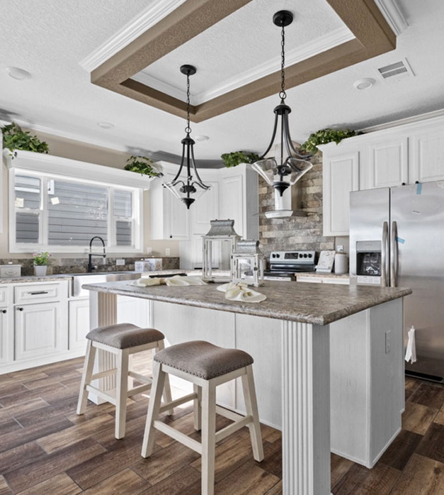 Elegant kitchen in a modern manufactured home, showcasing custom cabinetry, and stylish lighting fixtures