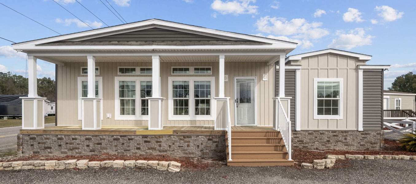 Front view of a manufactured home in Florida, featuring a spacious porch, raised foundation, and modern architecture